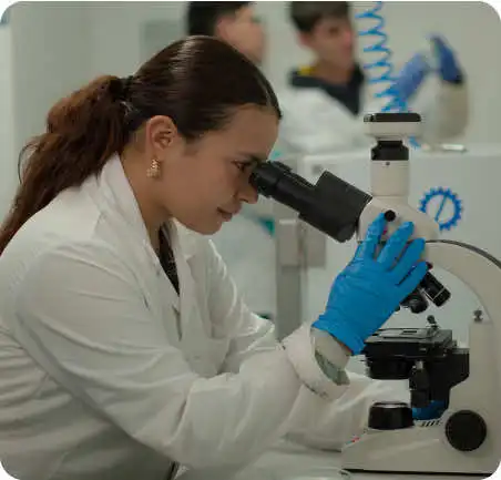 Estudiante de Ingeniería Química en laboratorio de la Universidad de América usando microscopio