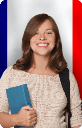 Estudiante con libro y mochila frente a la bandera de Francia en el Curso de Francés de la Universidad de América