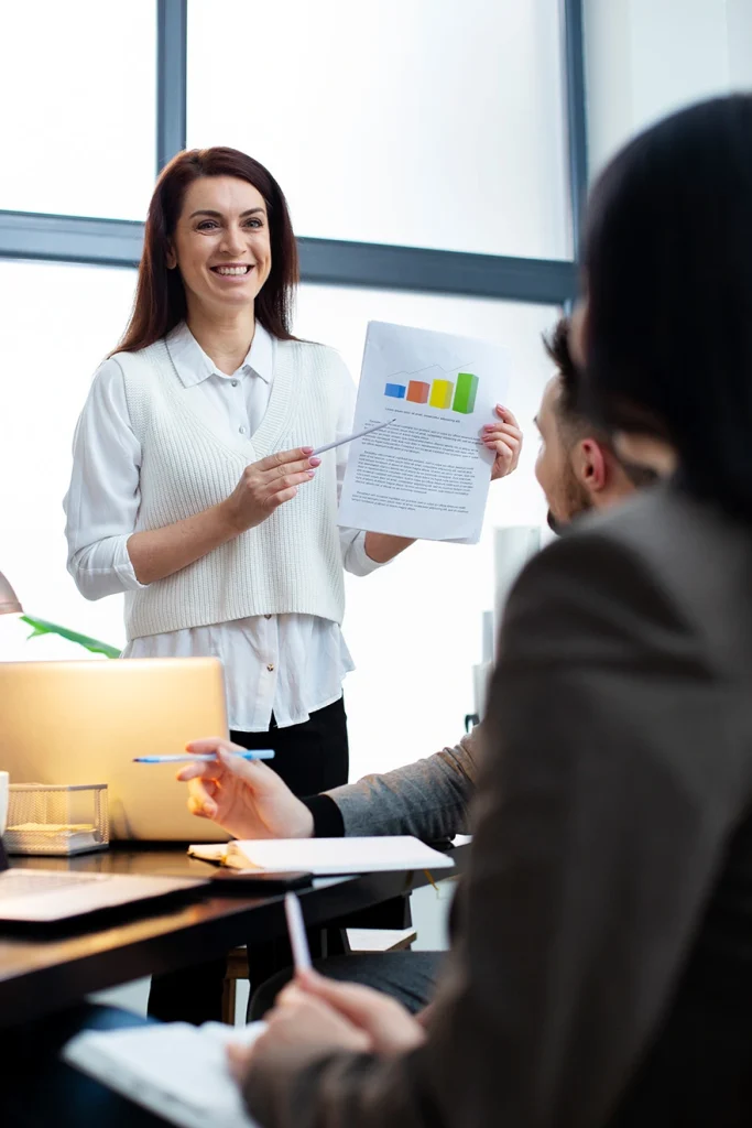 Docente presentando indicadores de gestión de calidad y productividad durante una clase en la Universidad de América.