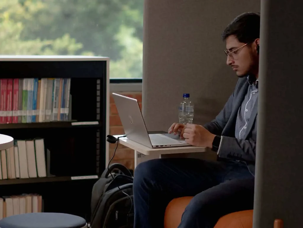 Estudiante realizando investigación en computador en el CRAI Universidad de América.