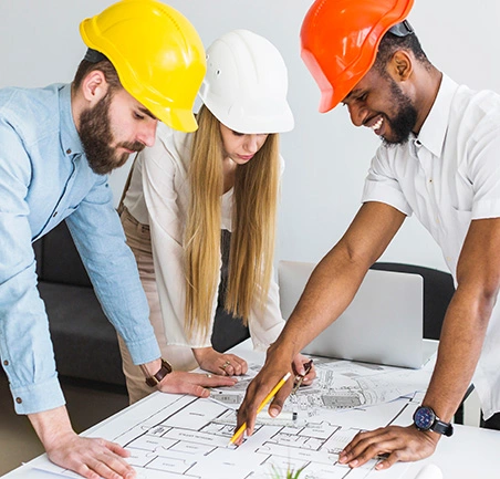 Equipo de ingenieros trabajando en planos de construcción en la Especialización en Gerencia de Empresas Constructoras de la Universidad de América