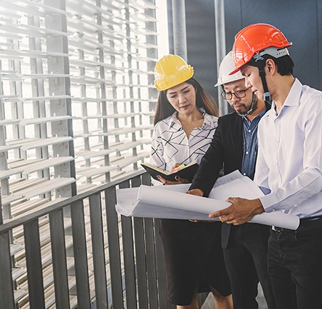 Profesionales dirigiendo revisión de planos en la Especialización en Gerencia de Empresas Constructoras de la Universidad de América