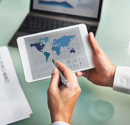 Especialización en Negocios Internacionales e Integración Económica 4 Profesional revisando mapa global en dispositivo digital en la Especialización en Negocios Internacionales e Integración Económica de la Universidad de América