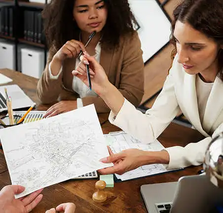 Profesionales revisando planos urbanos en la Especialización en Planeación Territorial de la Universidad de América