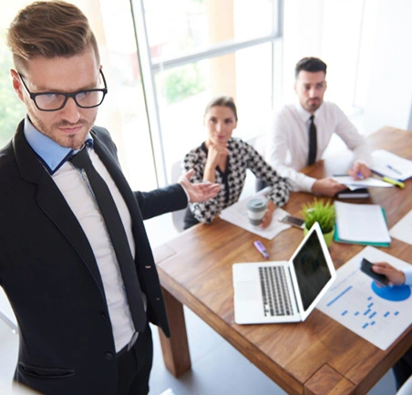 Líder empresarial guiando reunión estratégica sobre mejora de procesos y gestión de calidad.