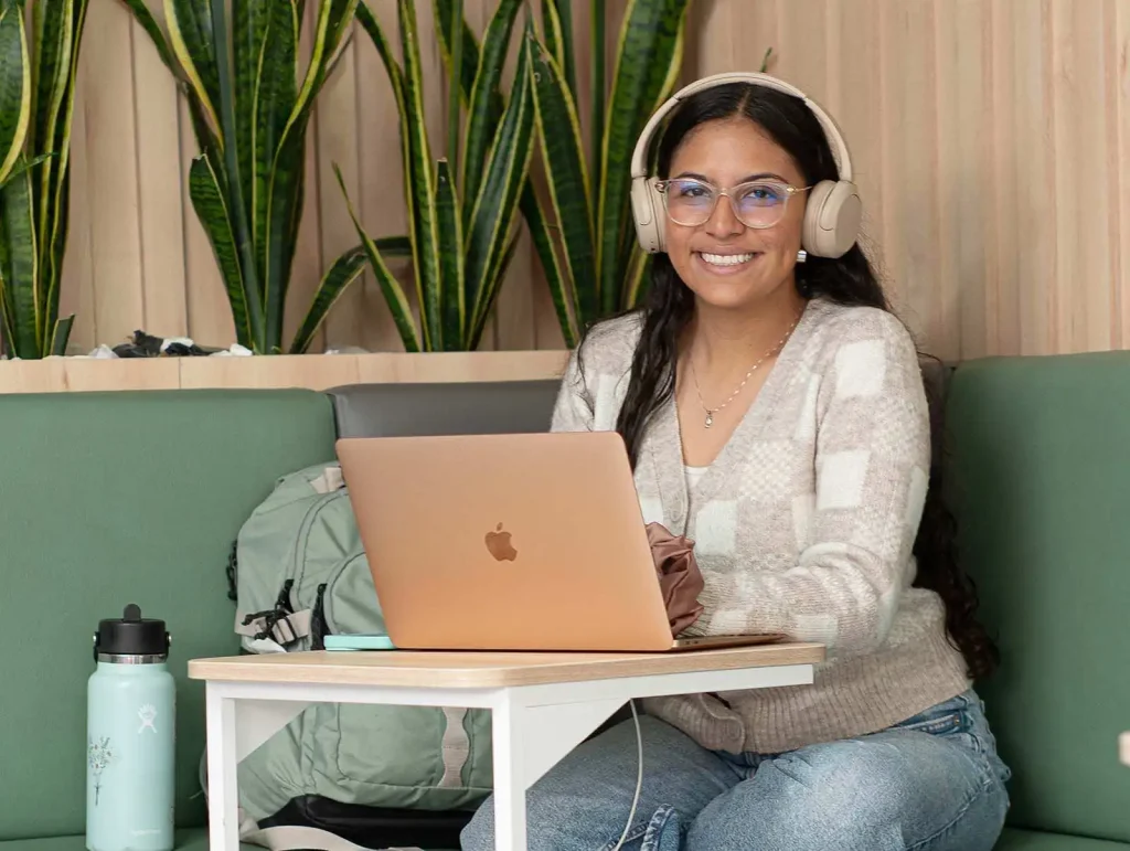 Estudiante estudiando en el CRAI Universidad de América con portátil
